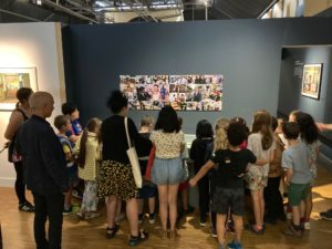 Enfants découvrant les appareils photos de Philippe Schuller